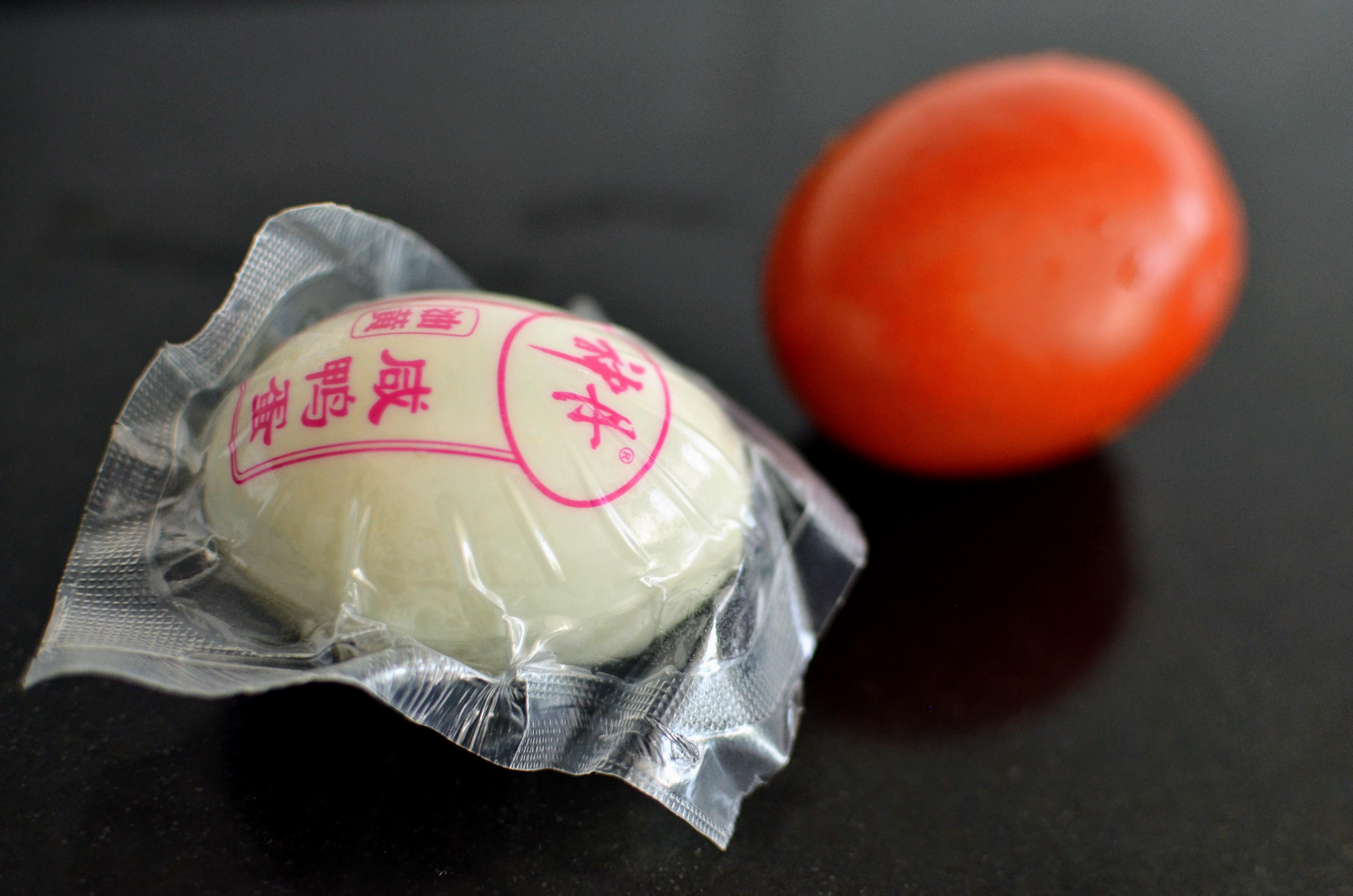 Salted eggs — one in its classic red shell, the other in its original packaging