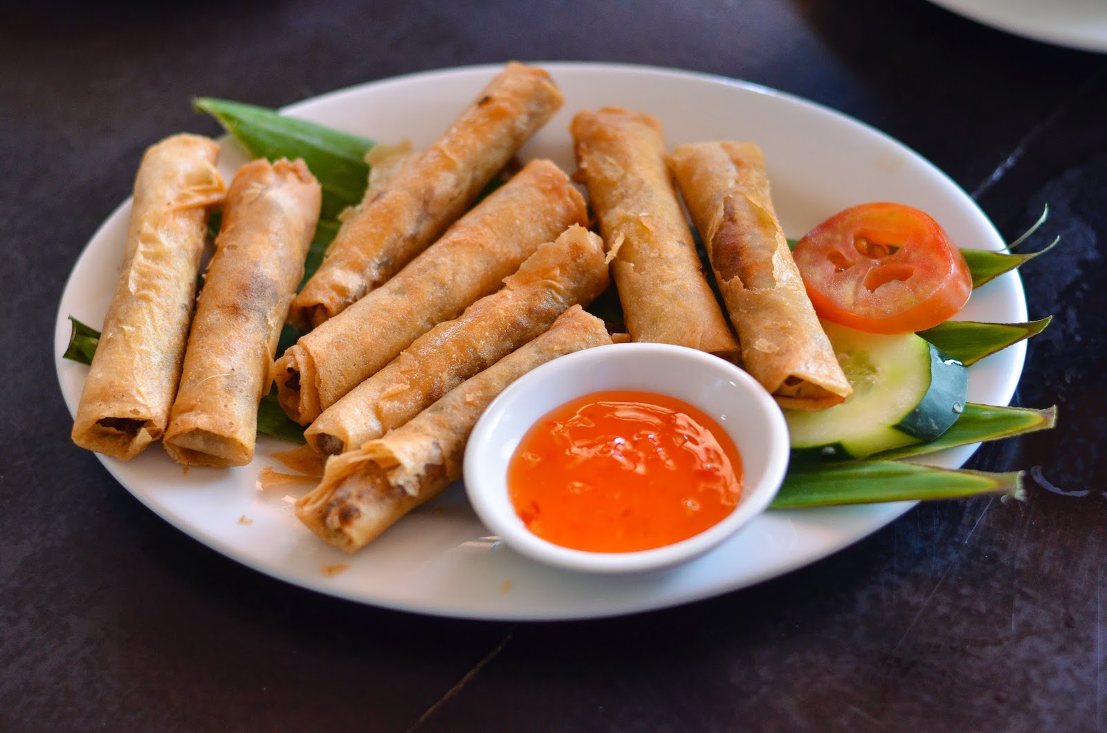 Lumpiang Shanghai served on a plate with sweet-chili sauce dip