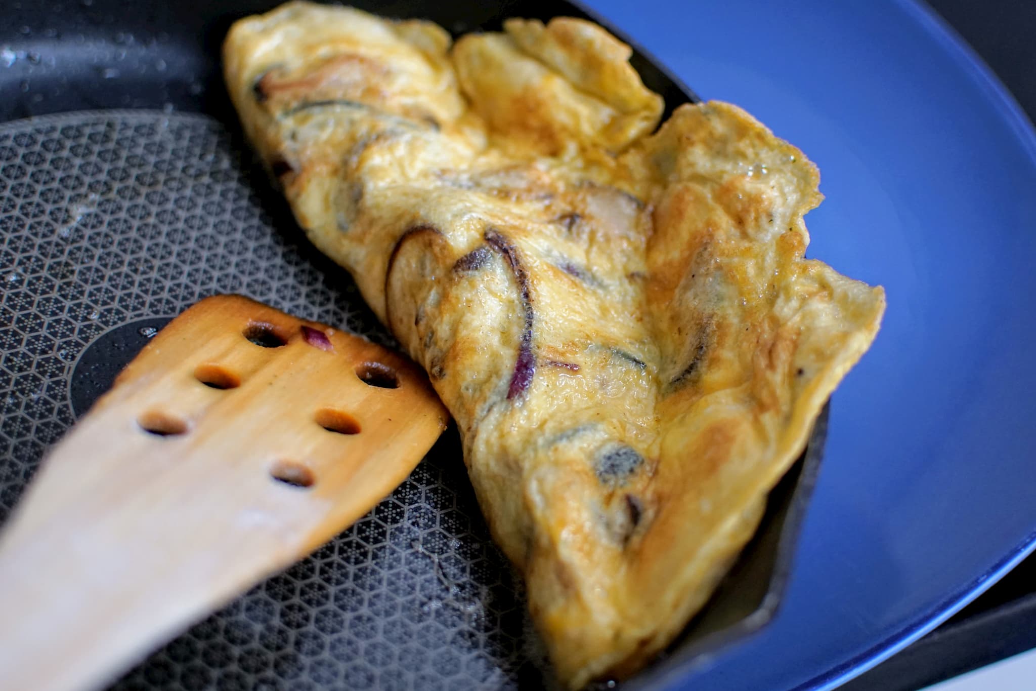 Red onion omelette in a skillet pan
