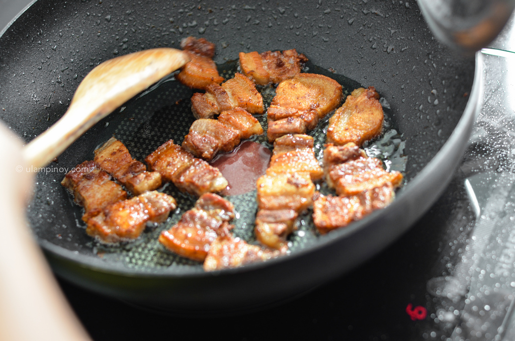 Golden brown pork belly strips in a wok