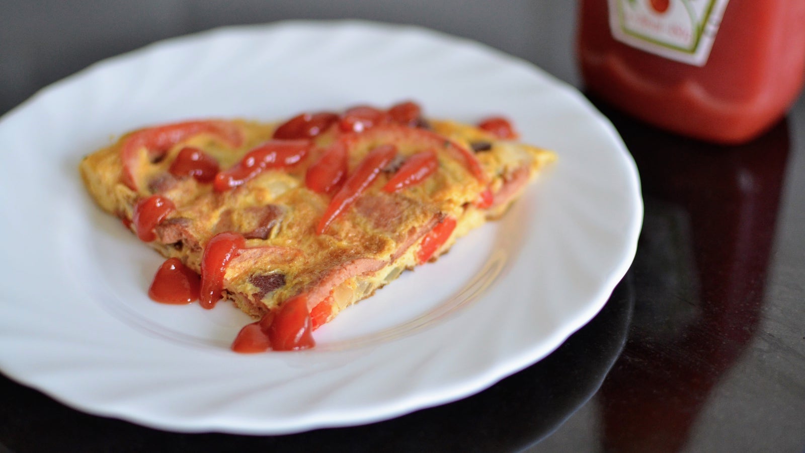 Slice of tortang hotdog with ketchup